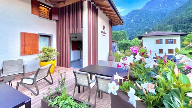 Un hôtel doté d’un patio aménagé avec des espaces de détente en plein air et des plantes en pot.