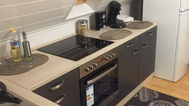 A compact kitchen with a built-in oven, a coffee machine, and a refrigerator. - 2 Zimmer Wohnung in Ludwigsburg Mitte (Ludwigsburg)