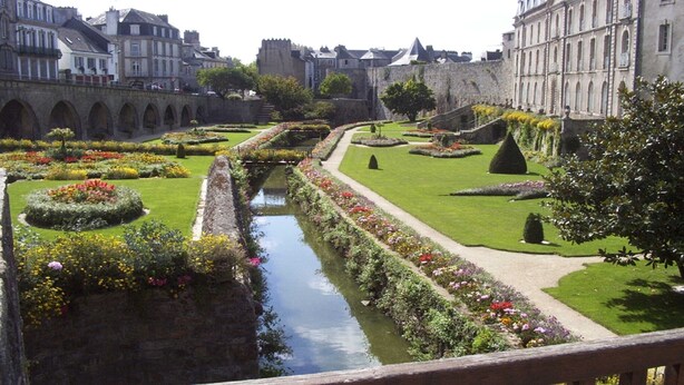 A historic courtyard with a central water feature, surrounded by manicured gardens and classical architecture. - Gite sleeps 6 - heated indoor swimming pool (Évellys)