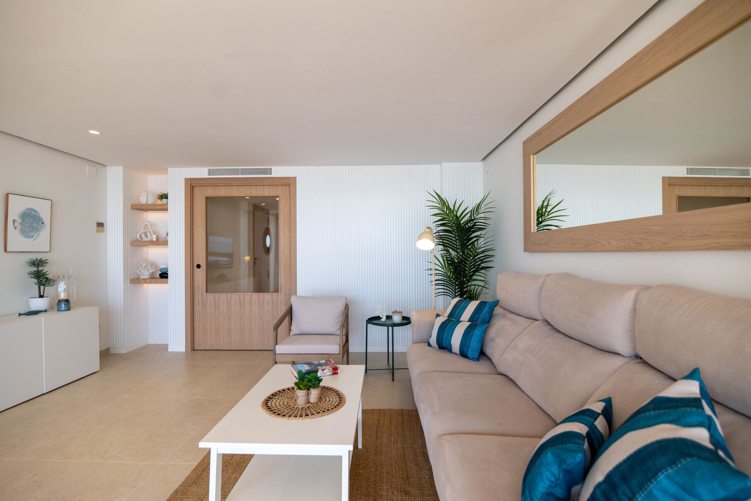 Een moderne woonkamer met een bank, een salontafel, een fauteuil en een boekenkast.