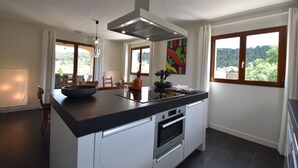 Una cocina moderna con una isla grande, horno empotrado y vistas al exterior.