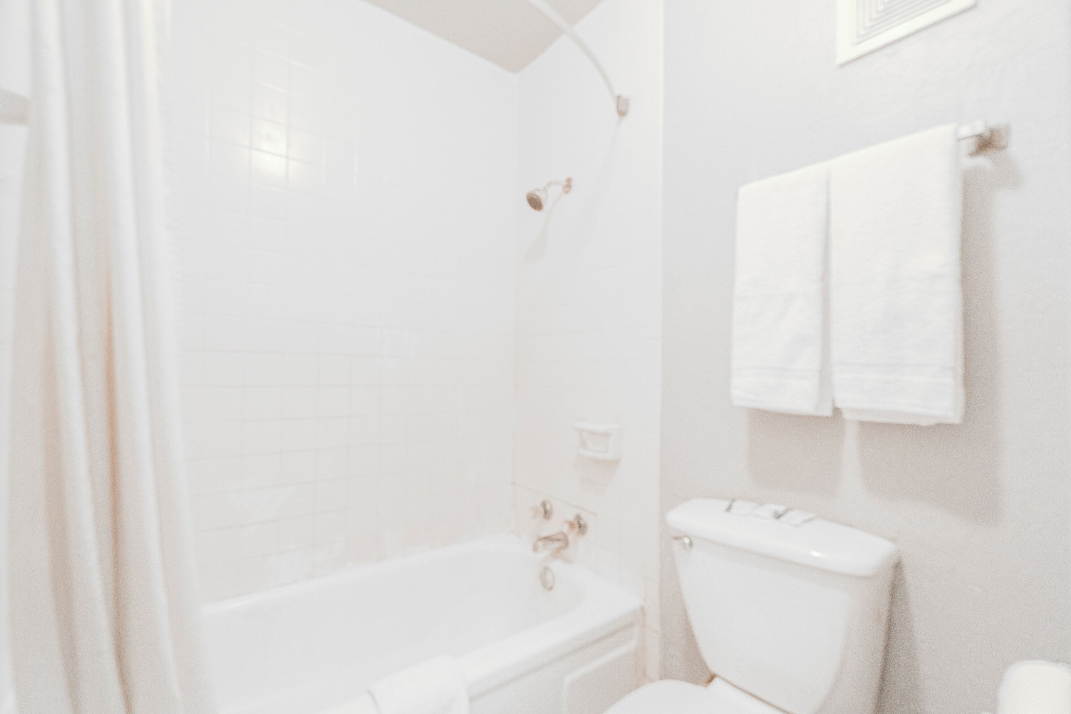 A bathroom with a bathtub, toilet, and a towel rack.