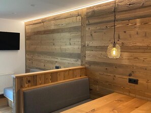 A modern interior with a wooden wall panel, a bench, and a hanging light fixture. - 2 room apartment no. 2 - Alt Filzmoos, Das Anja (Filzmoos)