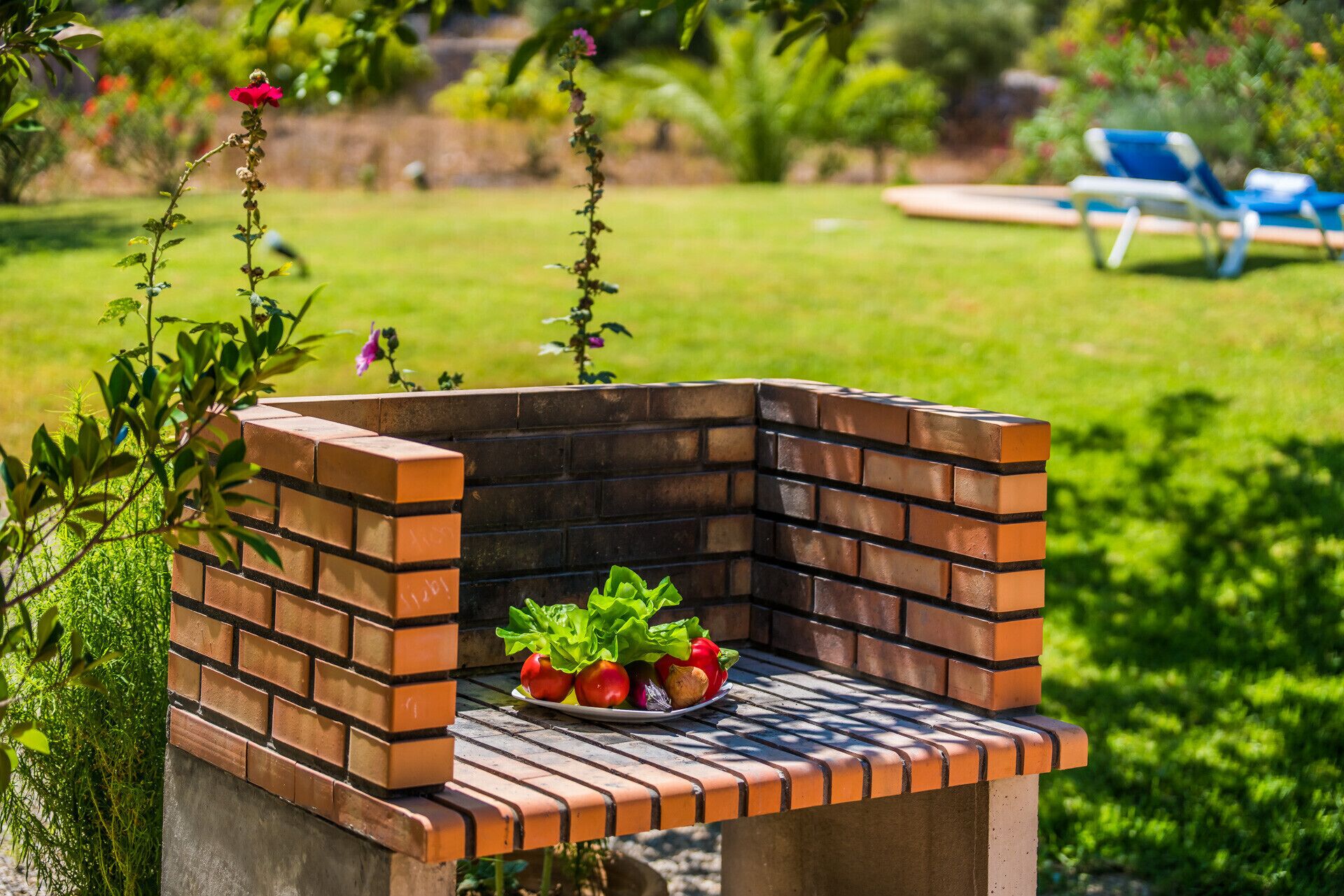 Una parrilla de ladrillo al aire libre con un plato de verduras.