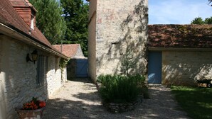 A courtyard with stone buildings, a gravel path, and a wheelbarrow. - Former sheepfold renovated, quiet, with heated pool. (Montgesty)