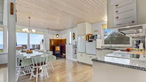 Una cocina amplia con una isla central, un área de comedor con vistas y una chimenea acogedora.