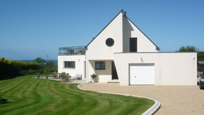 A modern two-story house with a white exterior, a garage, and a well-maintained lawn. - House exceptional sea view on the Pink Granite Coast (Penvénan)