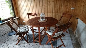 Una habitación con paneles de madera, una mesa redonda y seis sillas, cada una con asiento acolchado.