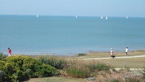 A coastal view with a grassy area, a path, and the sea with sailboats. - 3 room apartment La Rochelle Les Minimes - Seaside (La Rochelle)