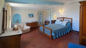 Ein Schlafzimmer mit Bett, Stuhl, Kommode und Nachttisch.