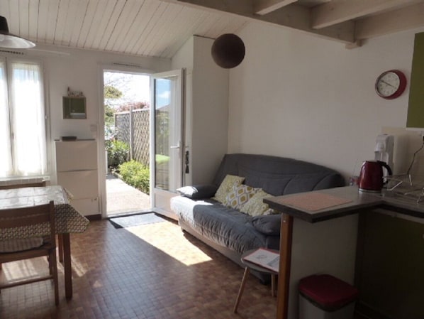 Een knus woongedeelte met een bank, een eettafel en een kitchenette.