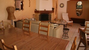 Un'area pranzo con un tavolo e sedie in legno, un camino e uno specchio a parete.