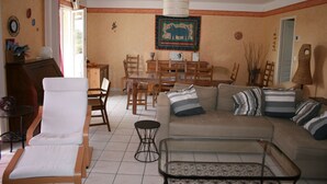 Un soggiorno con un divano, poltrone, un tavolo da pranzo e un tavolino in vetro.
