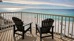 A balcony with two Adirondack chairs overlooking a beach with a clear view of the ocean. - Steps to the Sand at our Beachfront Condo at Majestic, 5th floor convenience  (Panama City Beach)