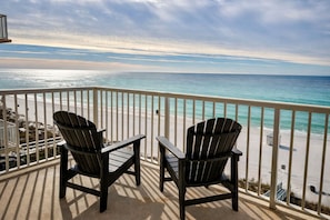 A balcony with two Adirondack chairs overlooking a beach with a clear view of the ocean. - Steps to the Sand at our Beachfront Condo at Majestic, 5th floor convenience  (Panama City Beach)