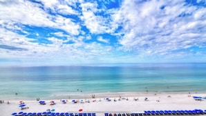 A beach with clear skies and calm waters. - Steps to the Sand at our Beachfront Condo at Majestic, 5th floor convenience  (Panama City Beach)