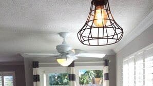 A dining area with a table, chairs, a ceiling fan, and a hanging light fixture. - Steps to the beach and restaurants!!! (St. Augustine)