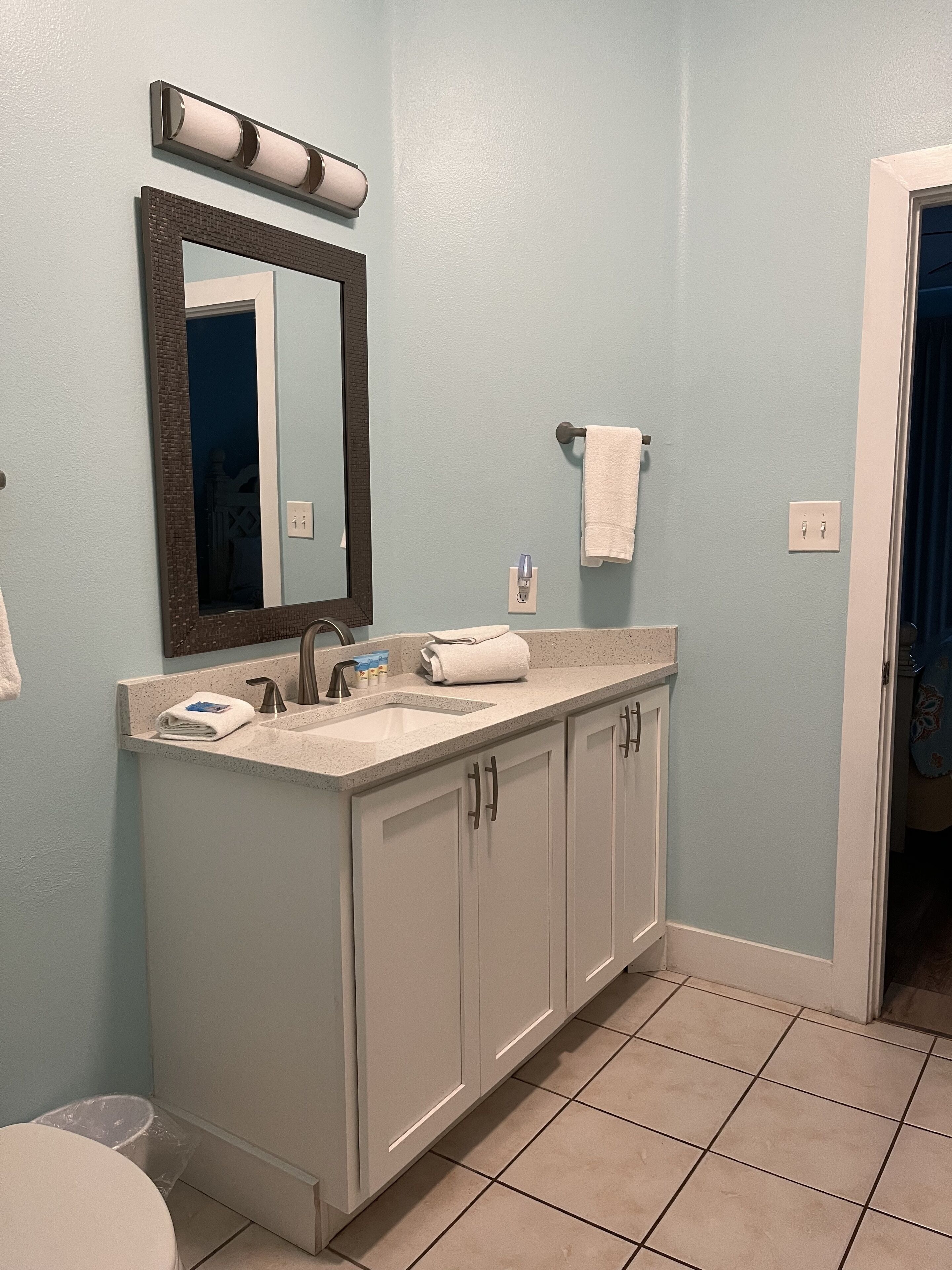 A bathroom with a sink, mirror, and cabinets.