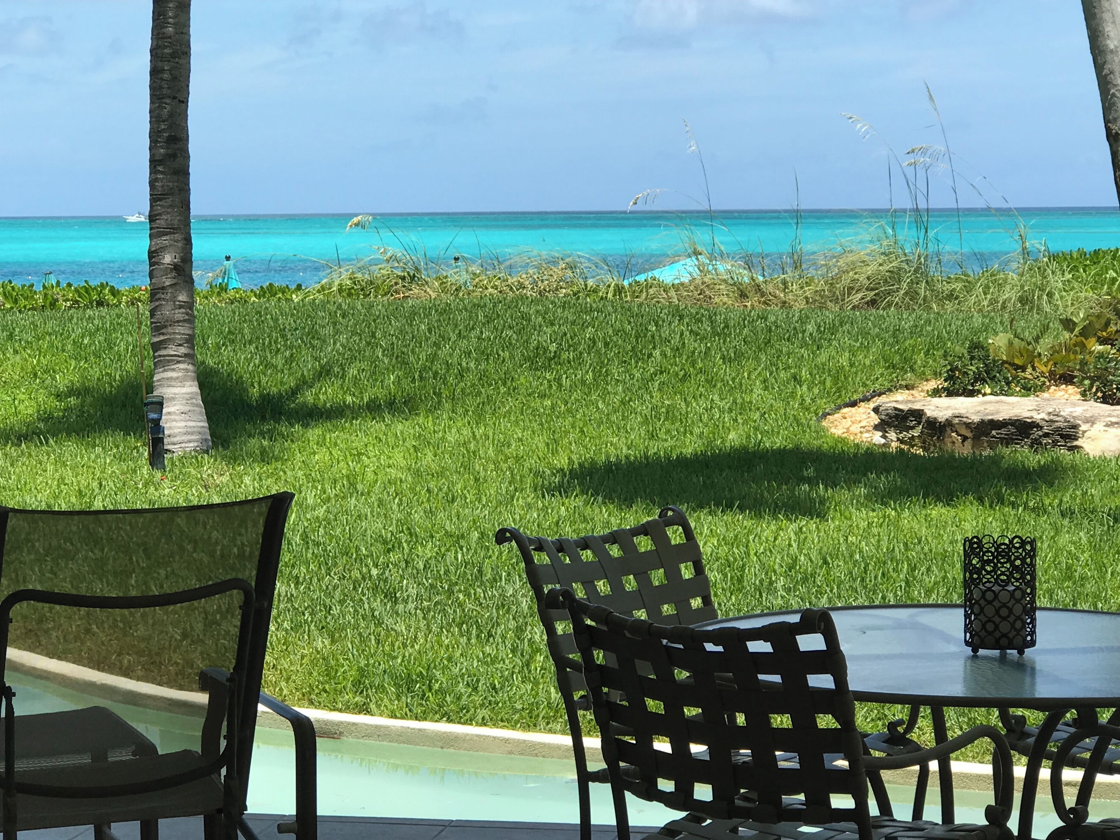A table and chairs with a view of the ocean.