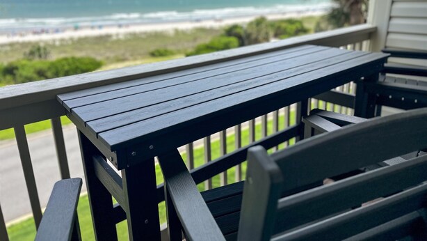 Une terrasse en bois offrant une vue sur la plage et l’océan.
