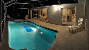 Ein Pool im Freien mit Liegestühlen und einer überdachten Sitzgruppe.