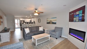 A modern living room with a grey sofa, a patterned blue sofa, a coffee table, and a fireplace. - Building 10  BEAUTIFUL! MAIN CHANNEL-NEW 2 KING BEDs/2BA-SLEEPS 6
WIFI (Osage Beach)