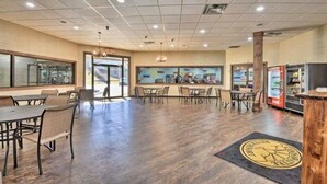 Un espace intérieur spacieux, aménagé avec des tables et des chaises, un distributeur automatique et une grande fenêtre offrant une belle vue.