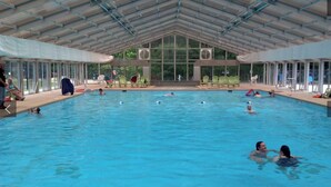 Une piscine intérieure dotée d’un toit couvert, de parois en verre transparent et de plusieurs couloirs de nage.