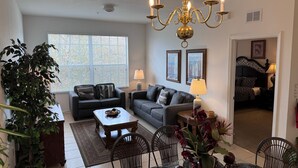 A living room with a chandelier, two sofas, a coffee table, and a dining area with chairs and a table. - Top floor on Disney's doorstep - Great location (Kissimmee)