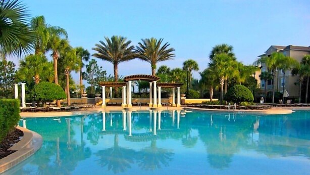 A clear swimming pool surrounded by palm trees and a gazebo. - Top floor on Disney's doorstep - Great location (Kissimmee)
