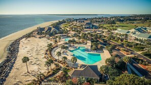 Un resort con una amplia piscina, acceso a la playa y un campo de golf.