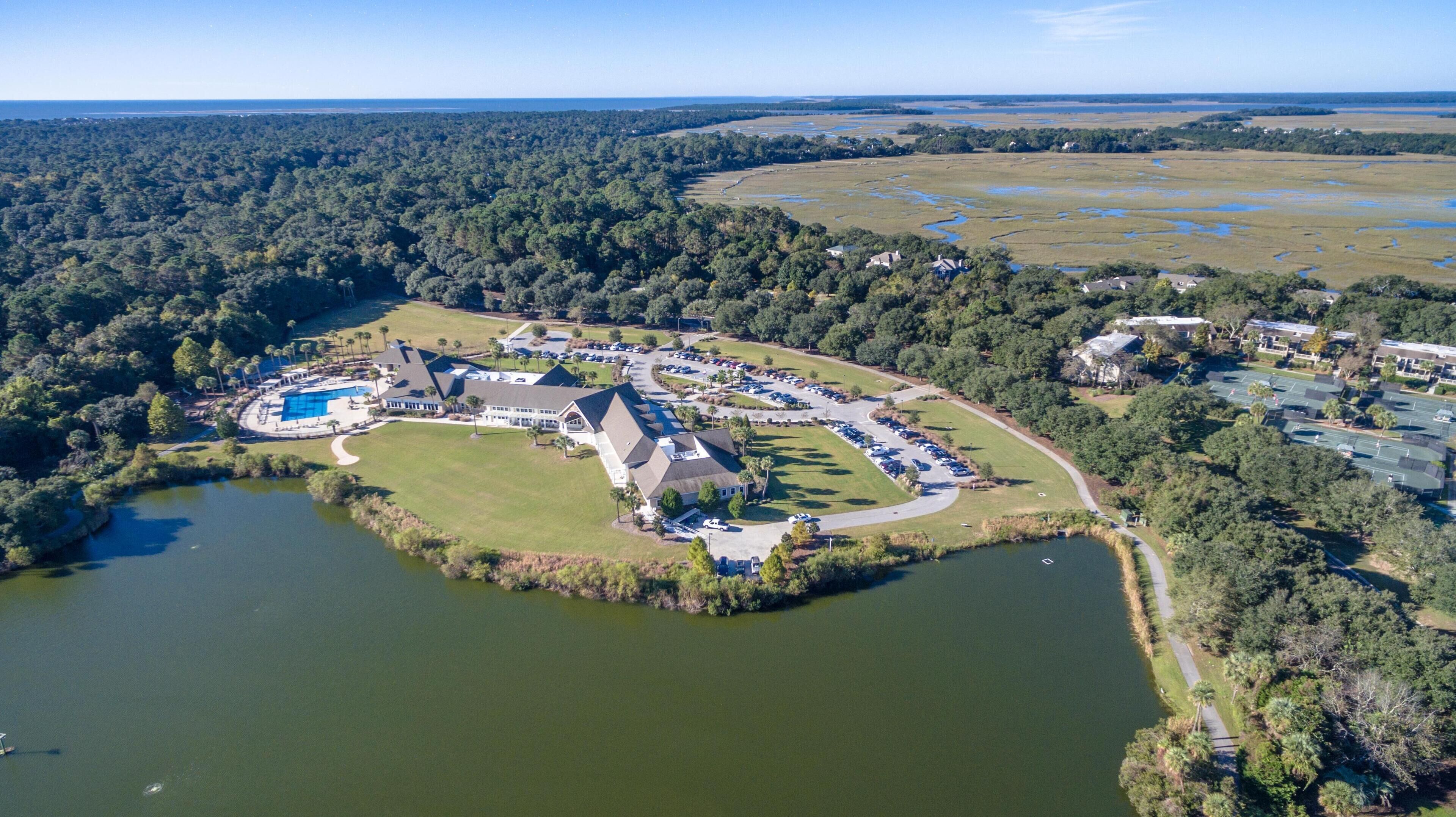 Vista aérea de un complejo turístico con una gran piscina, varias edificaciones y un paisaje natural circundante.