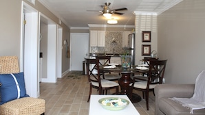 A dining area with a round table, chairs, and a ceiling fan.