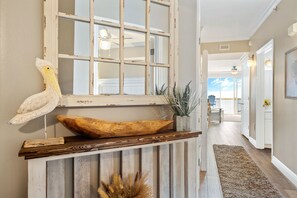 A hallway with a rustic wooden bench, a decorative wooden bowl, and a wall-mounted owl sculpture.