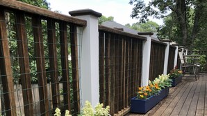 Un terrazza in legno con fioriere piene di diversi fiori.