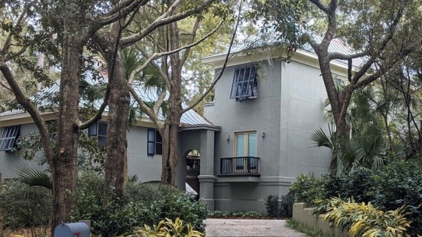 A two-story building with a grey facade, a small balcony, and a mailbox. - Gorgeous Home 5 minute walk to beach (Kiawah Island)