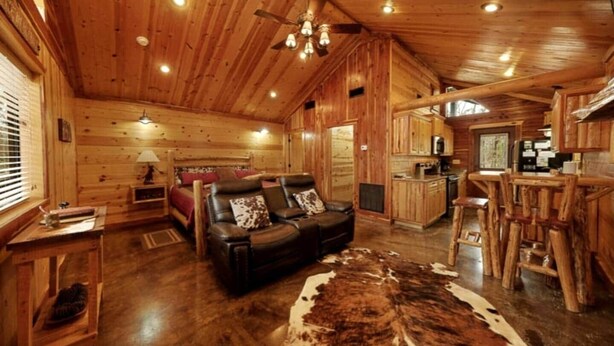 A log cabin interior with a living room, sofa, dining area, and kitchen. - Lucky Log (Broken Bow)