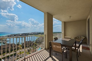Enjoy the serene coastal view from this balcony with a table and two chairs.