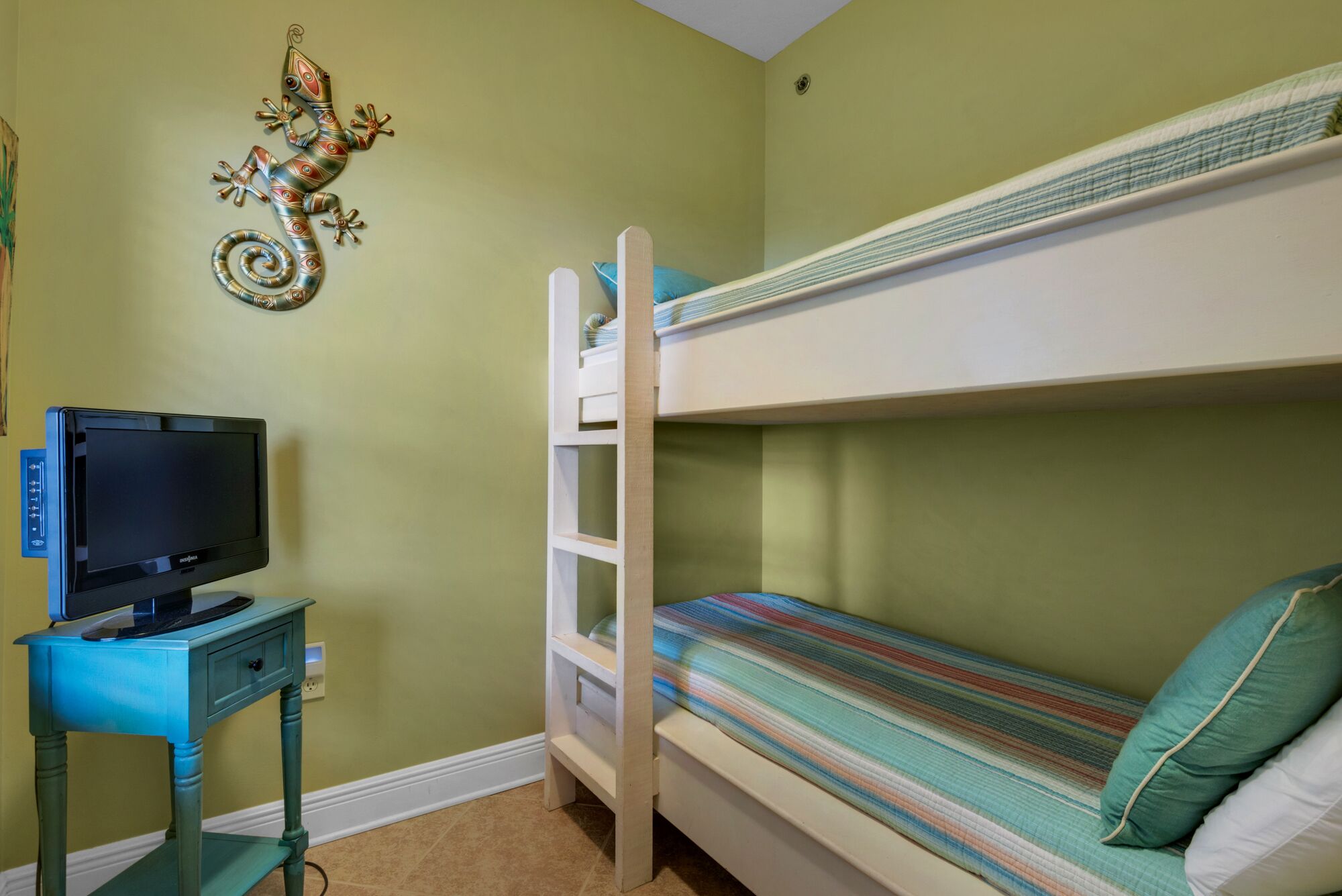 A bunk bed with a TV on a small table beside it.
