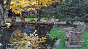 Um parque tranquilo com lago, bancos e folhagem outonal.