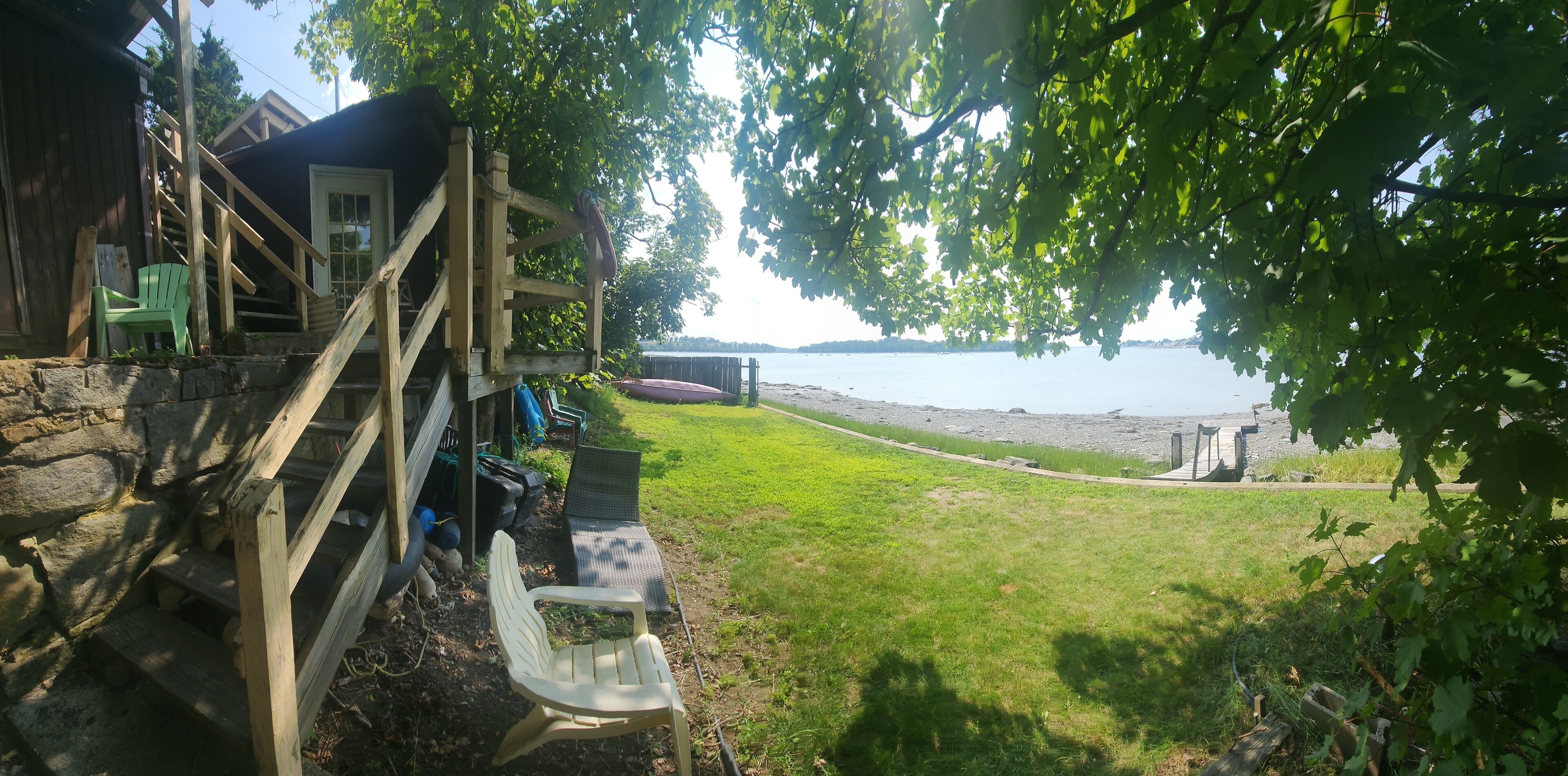 lower lawn area to the right is pier
beach visible, beach ocean view, handrail, summer, staircase, outdoor, body of water, outdoor space