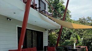 A poolside area with wicker furniture, a pool, and a covered seating area. - Private Rainforest Retreat with Infinity Pool & Concierge (Quepos)