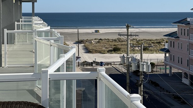 Ein Balkon mit Blick auf Strand und Meer.