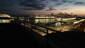 A nighttime view of a cruise ship docked at a port with a city skyline in the background. - Superb View Over the Marina Funchal 270º view (Funchal)