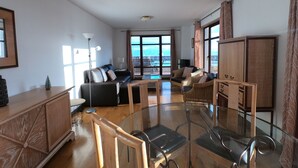 A spacious living area with a glass table, sofas, and a view of the sea. - Superb View Over the Marina Funchal 270º view (Funchal)