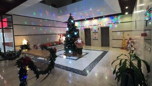 A spacious lobby with a large Christmas tree, a Santa Claus figure, and festive decorations. - Superb View Over the Marina Funchal 270º view (Funchal)