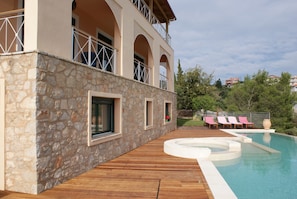 A stone building with a pool and wooden deck. - Breathtaking mediterranean view, large private infinite Pool & Jacuzzi ! (Theologos)