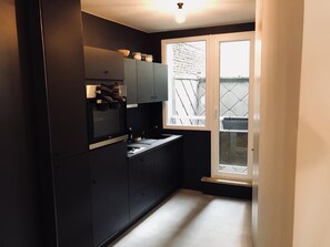 Een koffiezetapparaat/waterkoker, kookgerei, borden en bestek