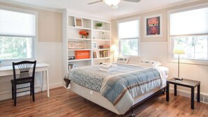 A bedroom with a bed, a desk, a chair, a bookshelf, and a ceiling fan. - Amazing Backyard, Spacious, Dog Friendly! (Dennis)