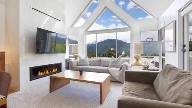 A modern living room with a fireplace, comfortable seating, large windows, and a mountain view. - LUXURY- 2BA/BA True Ski-in/Ski-out, HotTub&Pool (Whistler)